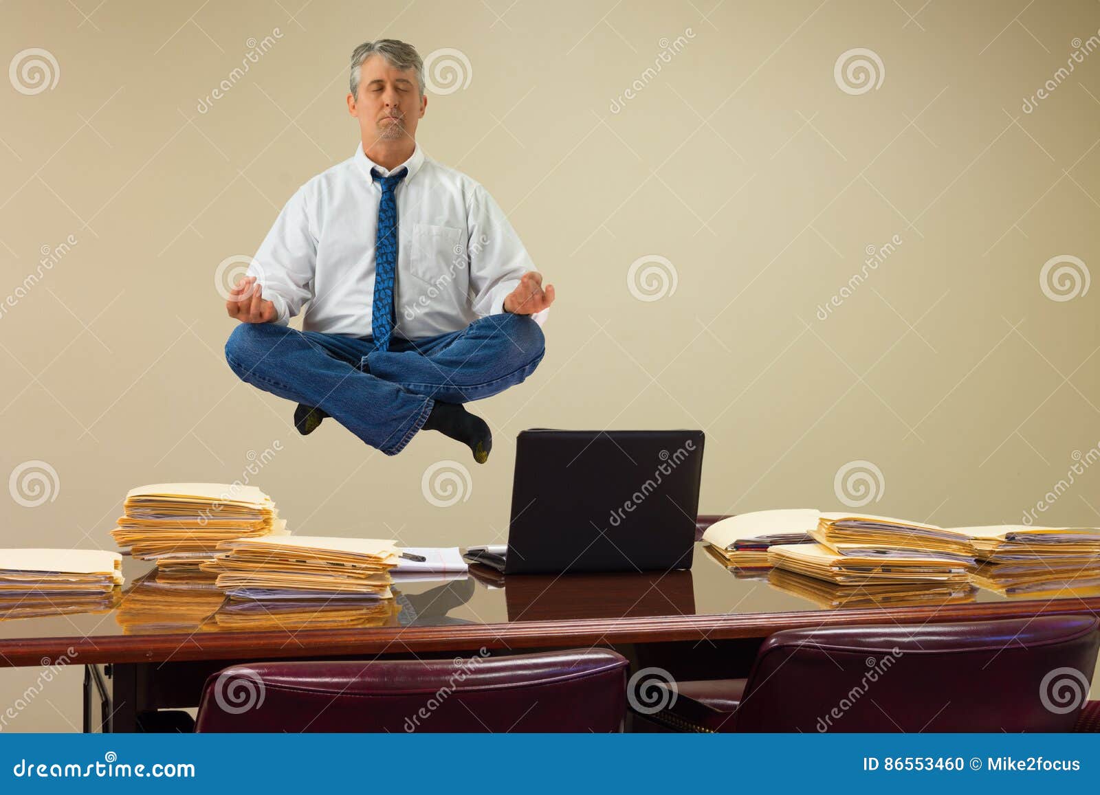 work related stress relief with yoga as man hovering over stacks of paperwork and computer