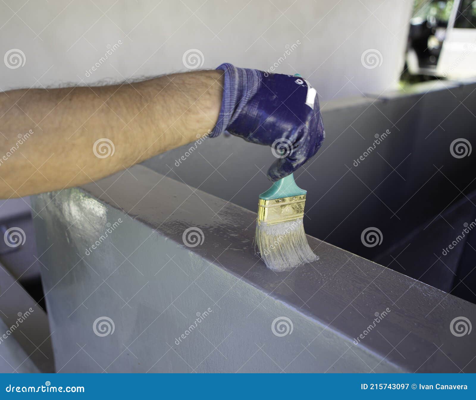 worker applies waterproofing with a small brush