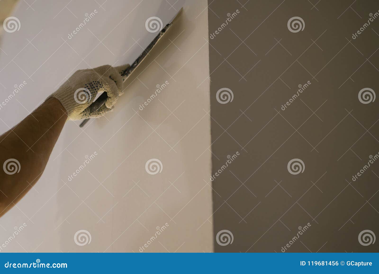 Worker Applying Putty On The Wall With Putty Knife Stock Photo