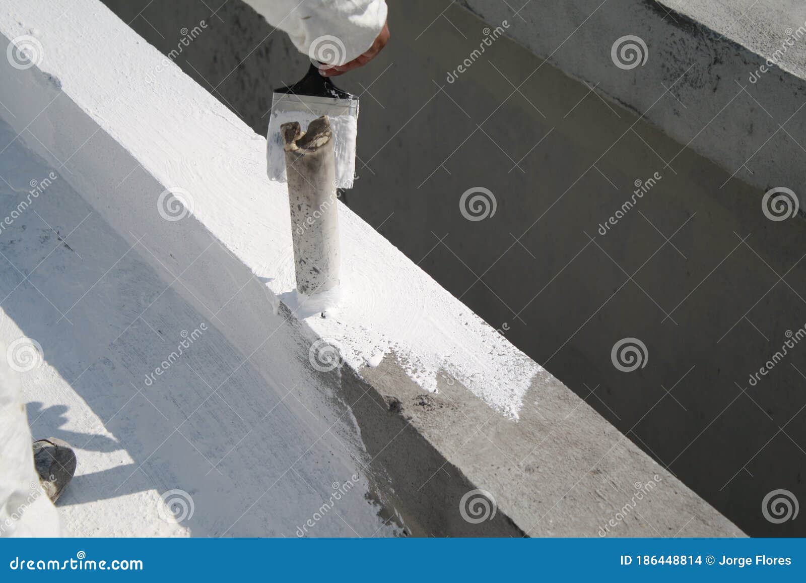 worker applying white roof coating