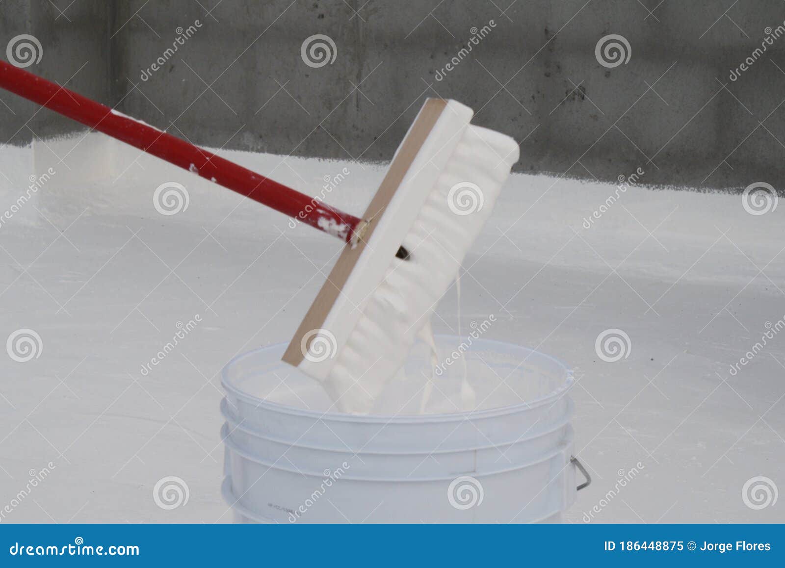 worker applying white roof coating