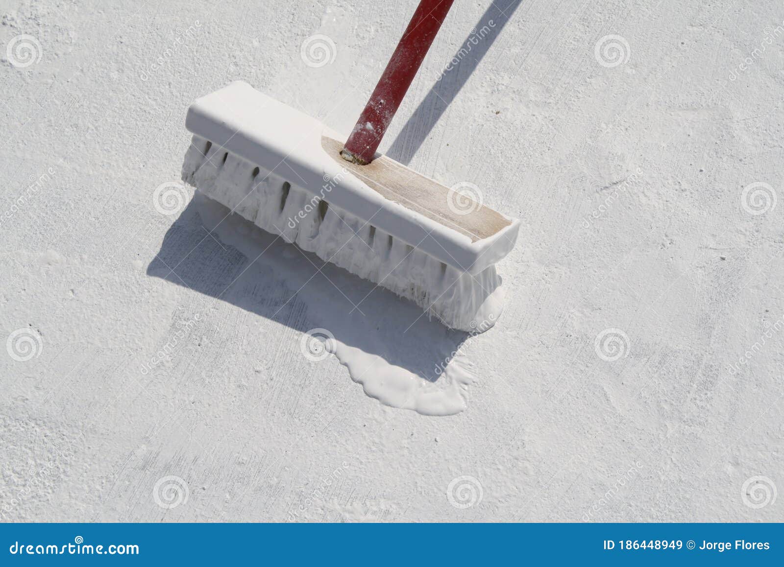 worker applying white roof coating