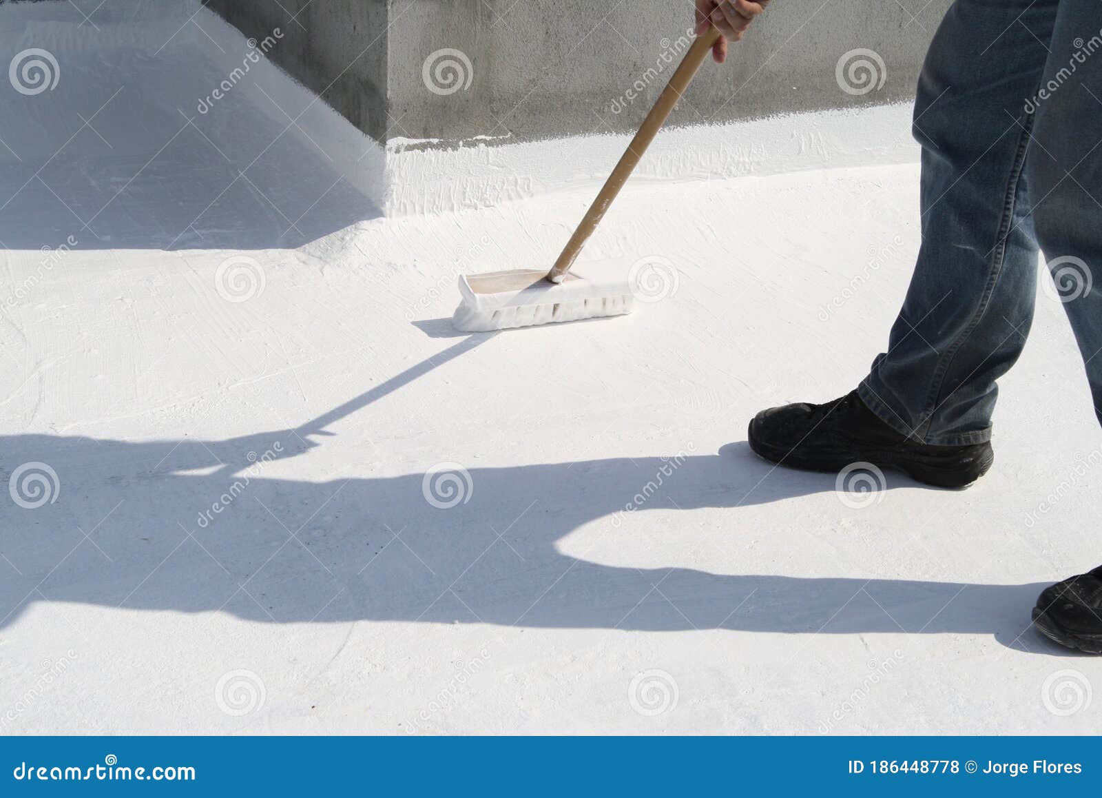 worker applying white roof coating