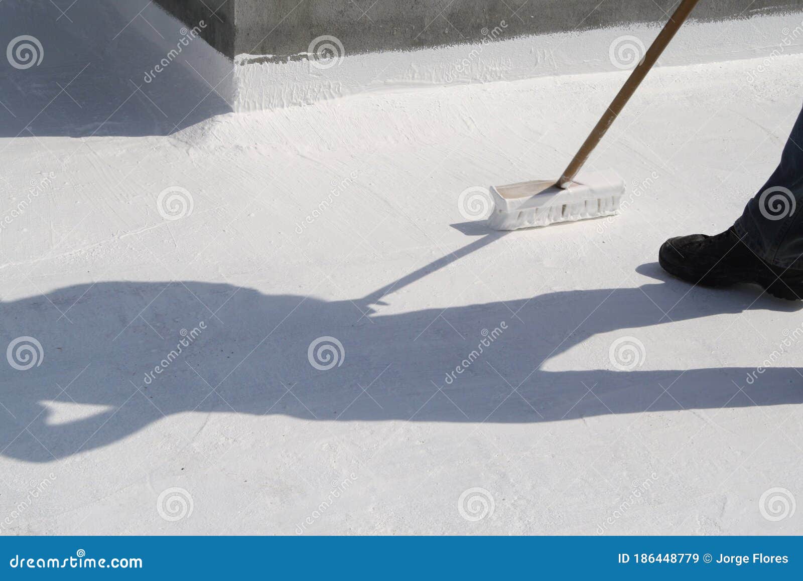 worker applying white roof coating