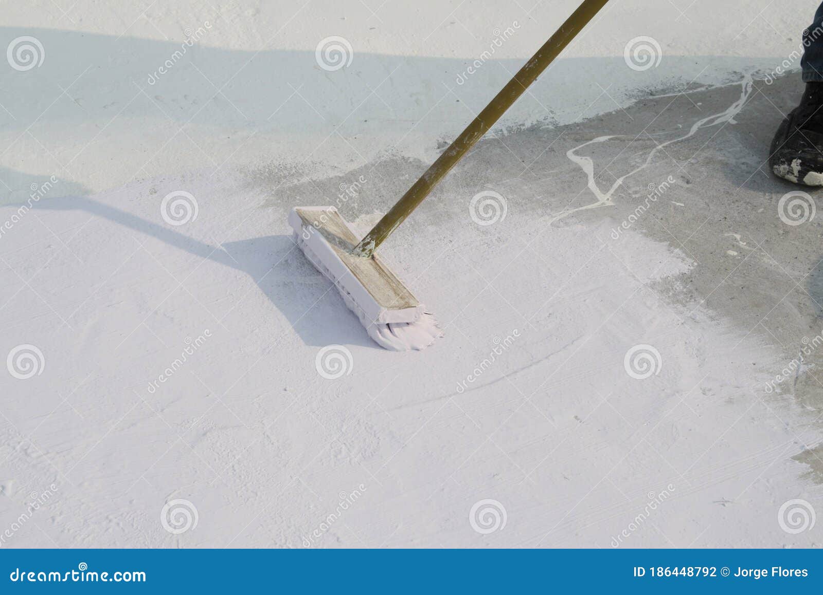 worker applying white roof coating