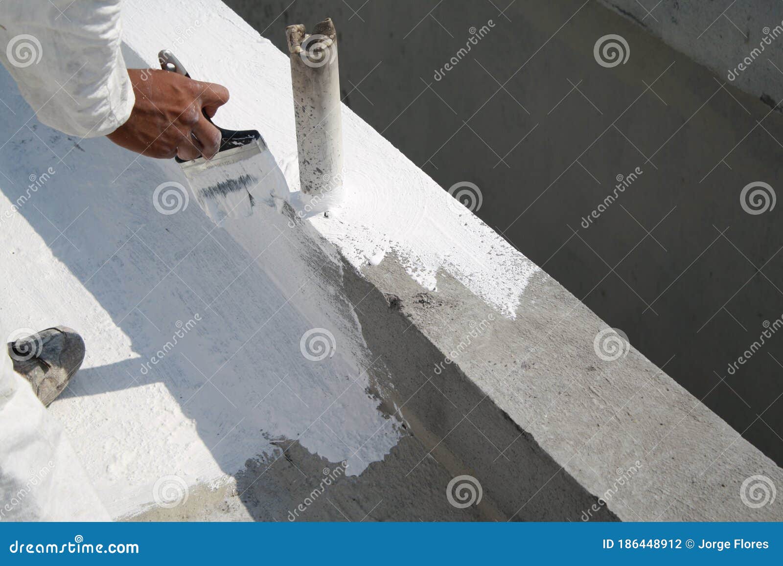 worker applying white roof coating