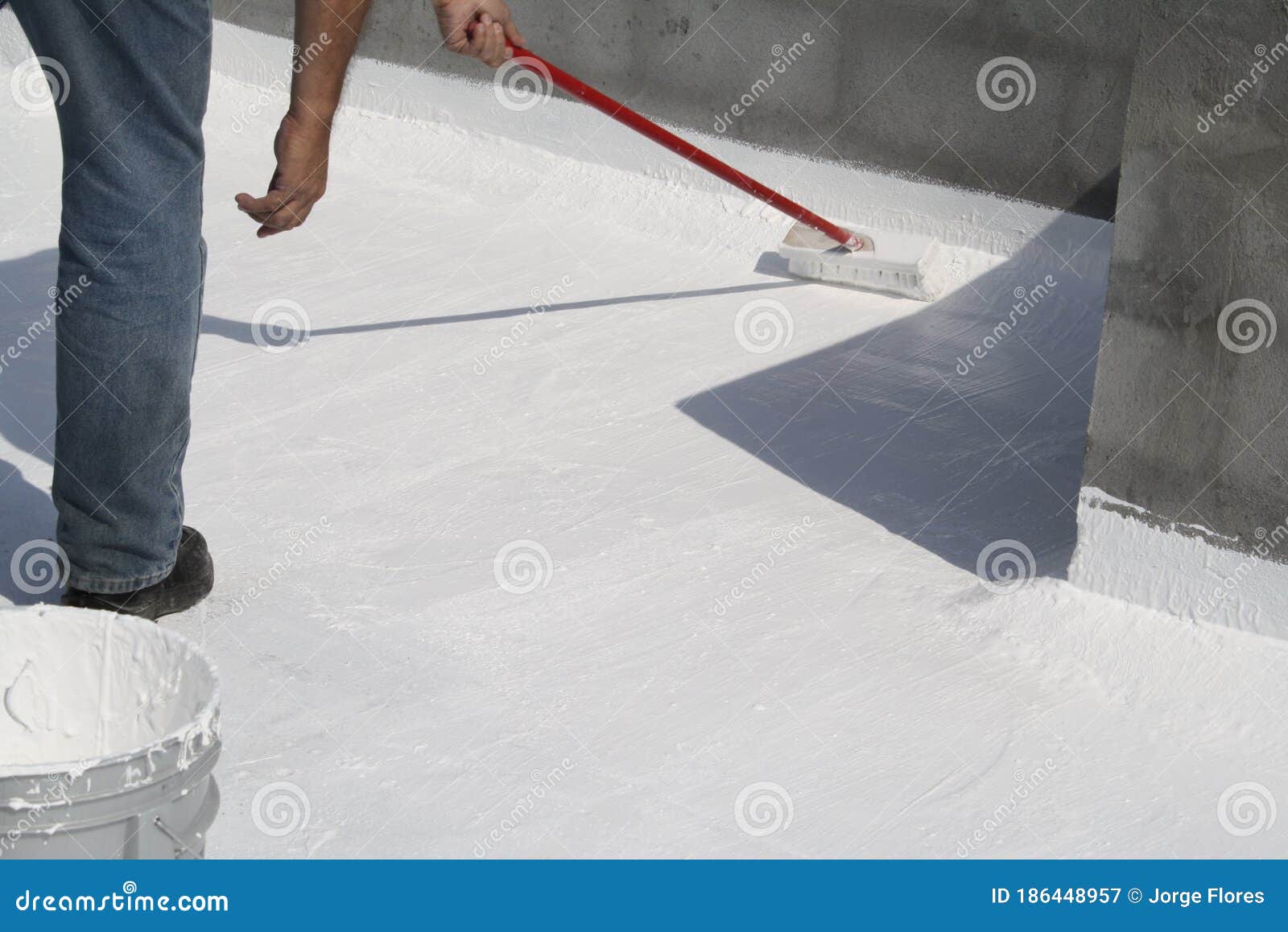 worker applying white roof coating