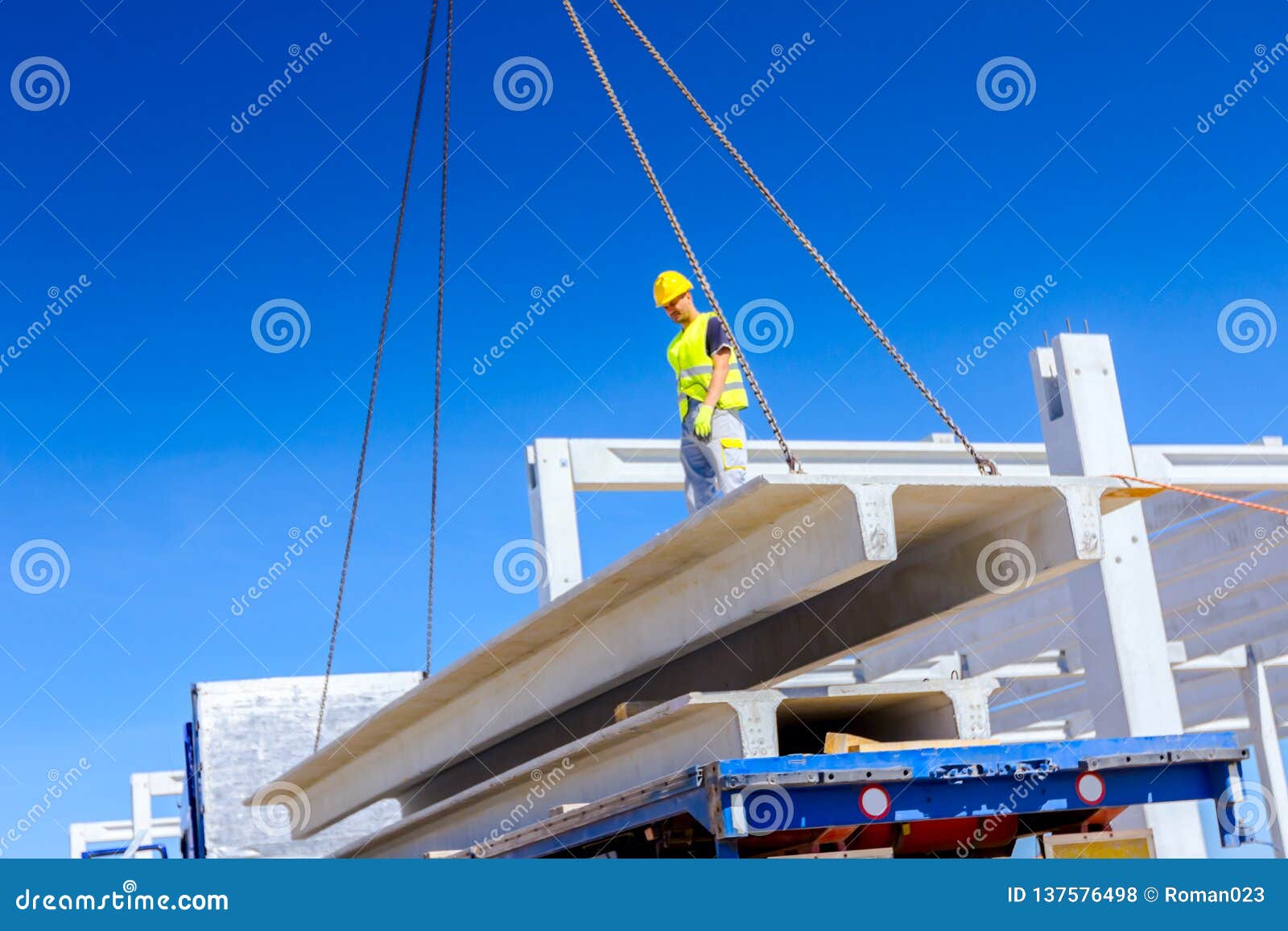 Worker is Attaching Crane Hooks To Concrete Joist in Truck Trailer
