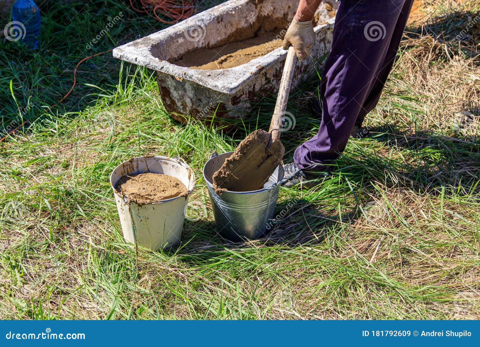 Worker with Buckets of Concrete at a House Construction Stock Image