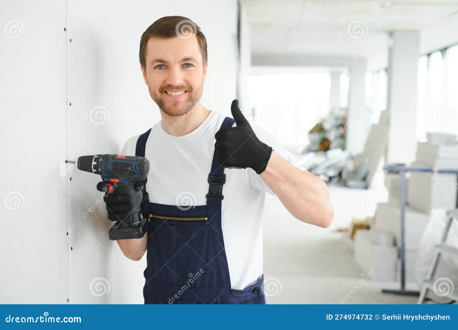 Worker Builder Installs Plasterboard Drywall at a Construction Stock