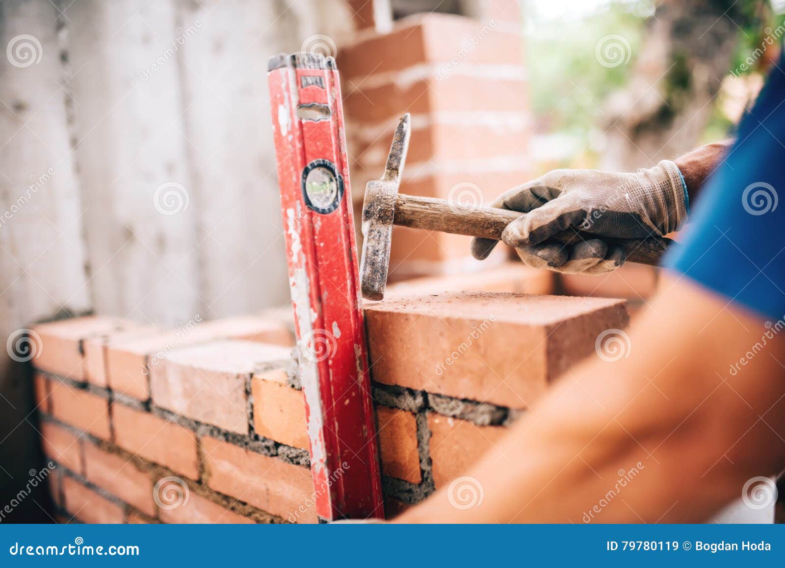 Worker Building Exterior Walls, Using Hammer and Level for Laying