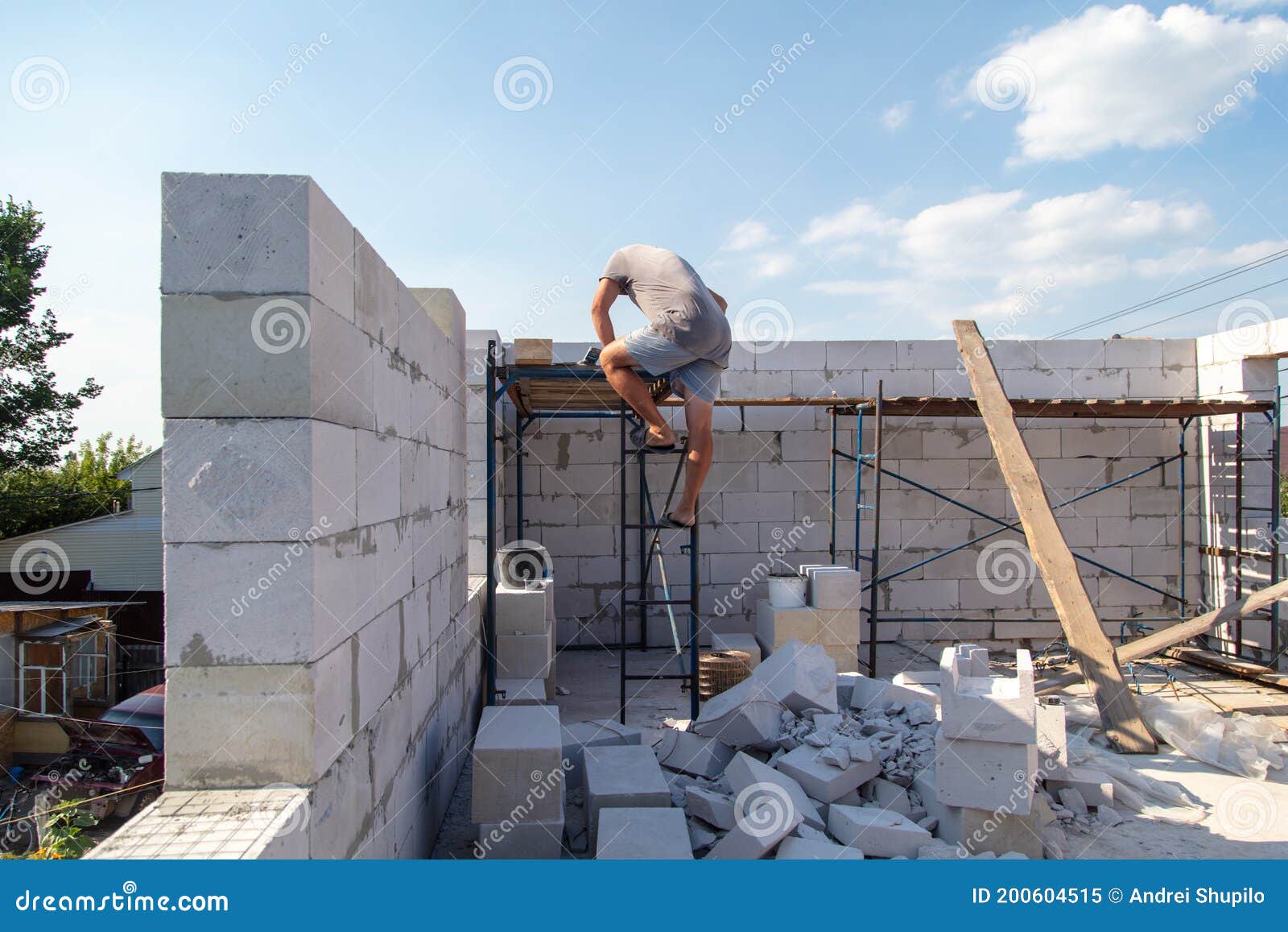 A Worker Builds the Walls of a House from Aerated Concrete Bricks