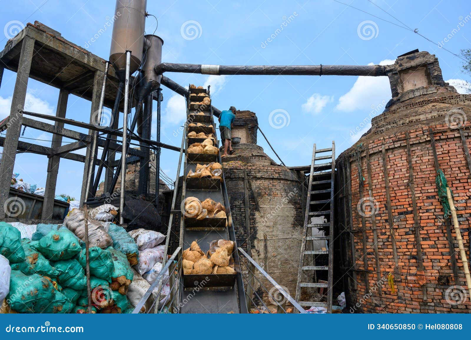vietnam, worker in a factory that processes coconuts. coconut shells are burned and processed into activated carbon filters.