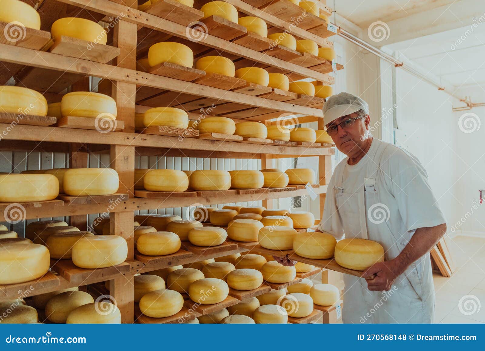 A Worker at a Cheese Factory Sorting Freshly Processed Cheese on Drying