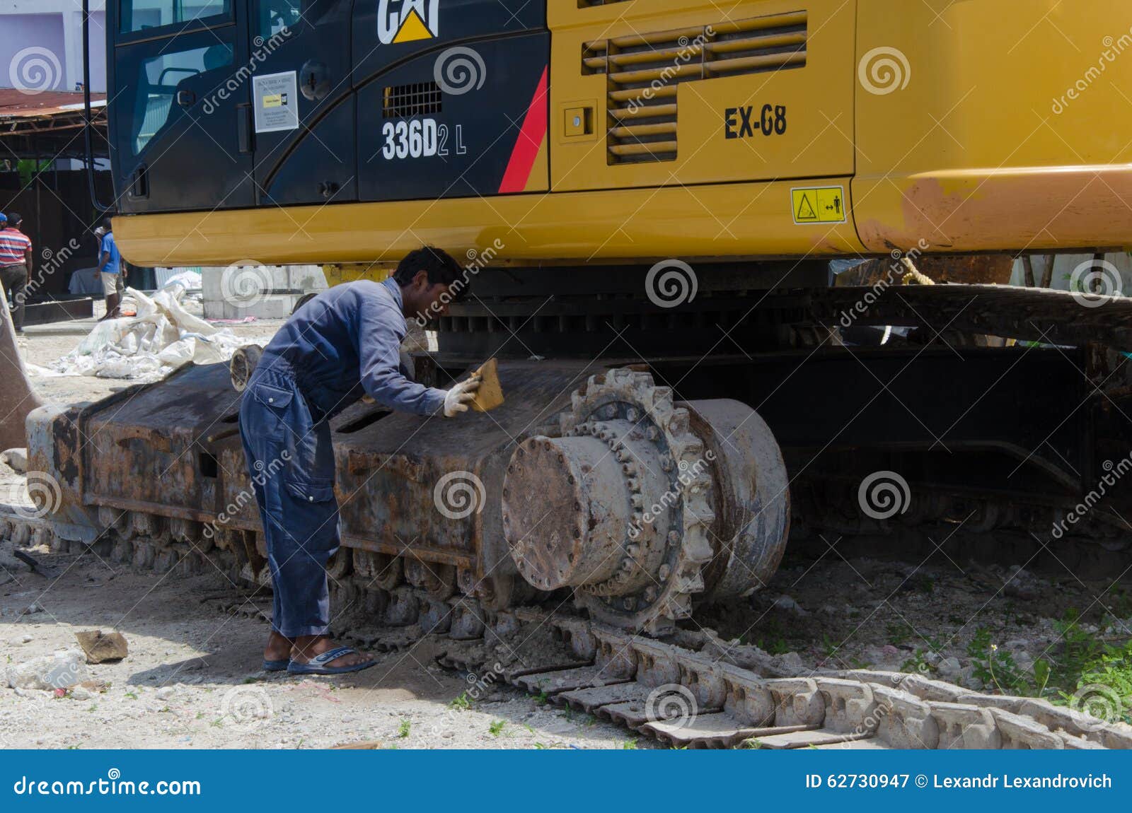 Worker Cleans Excavator at Construction Site Editorial Photography
