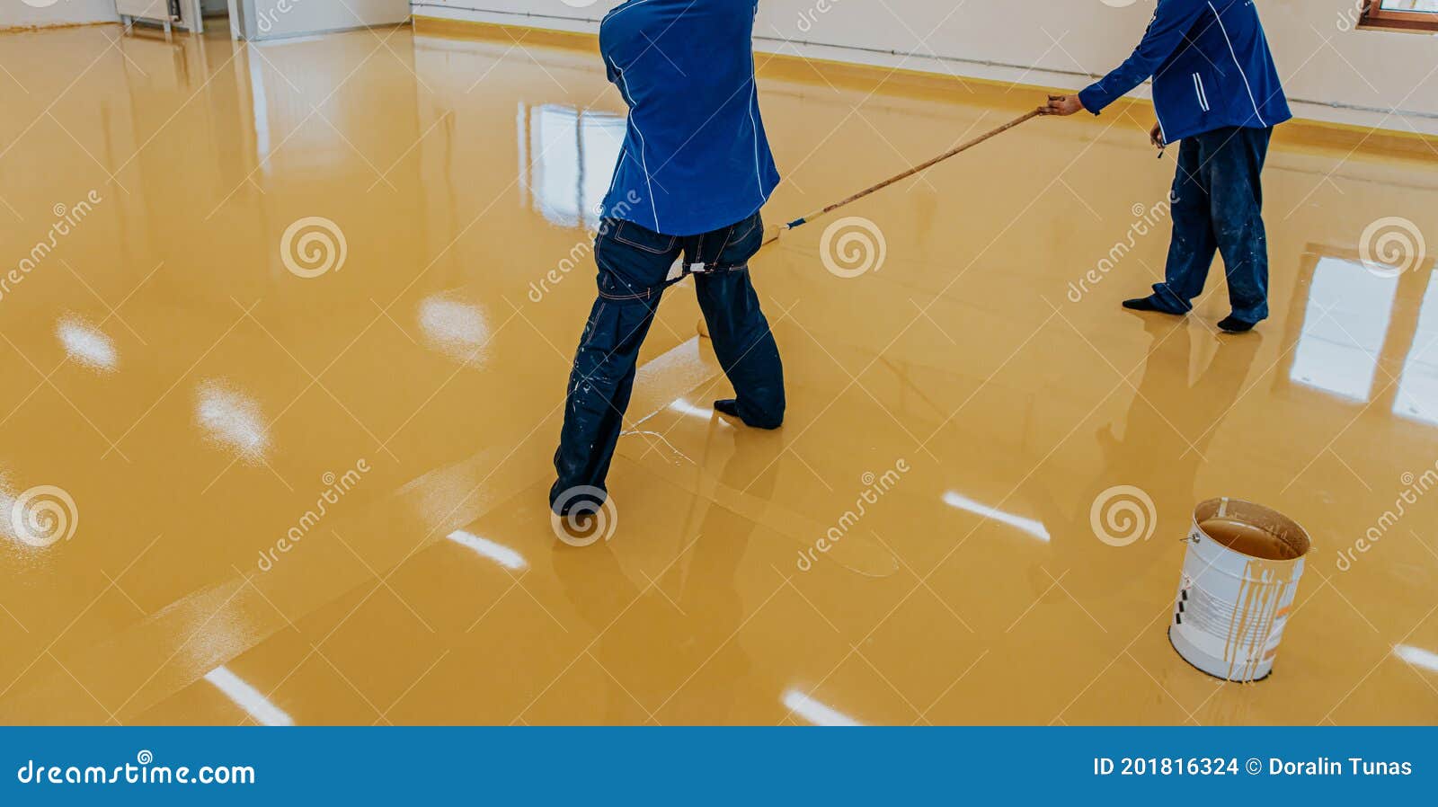 worker, coating floor with self-leveling epoxy resin