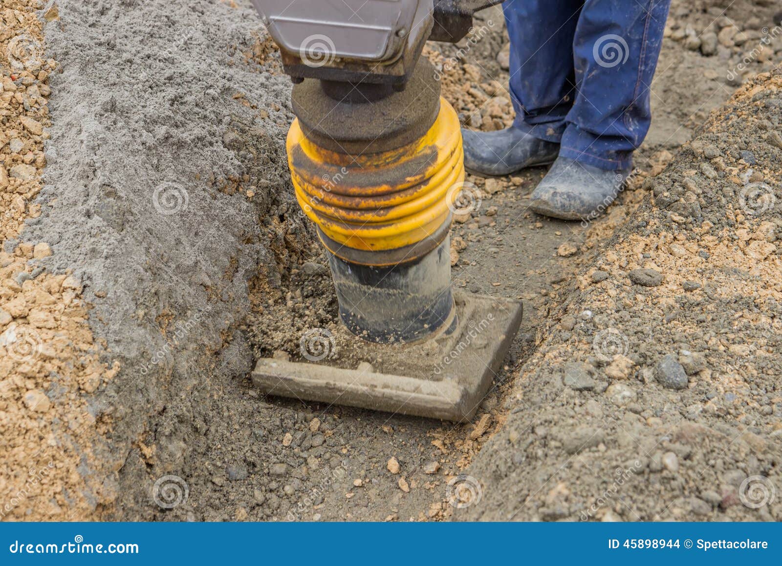 Worker Compacting the Sand Bedding with Mechanical Rammer Stock Photo