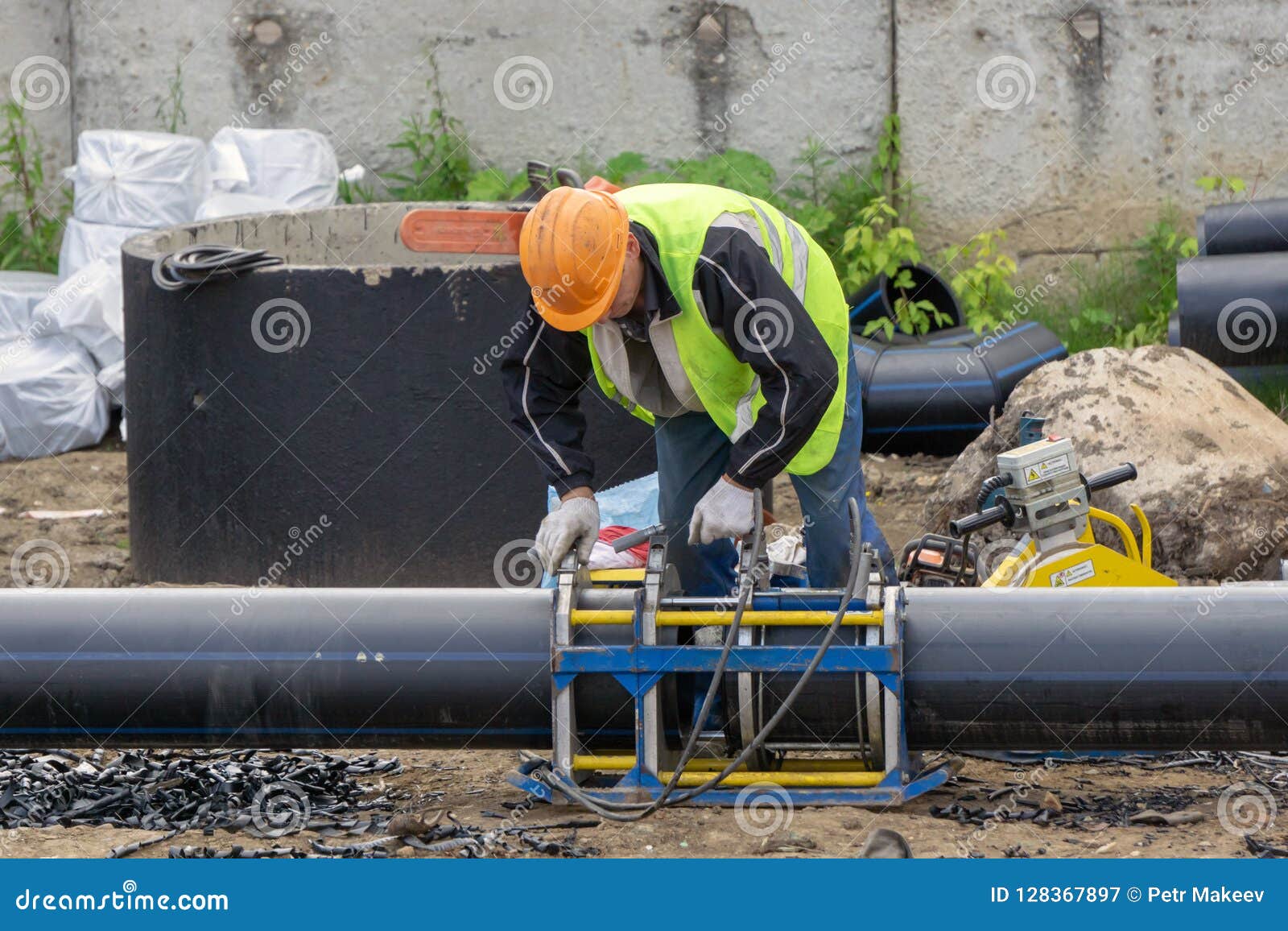 Worker at the Construction Site Connects the Pipes Editorial