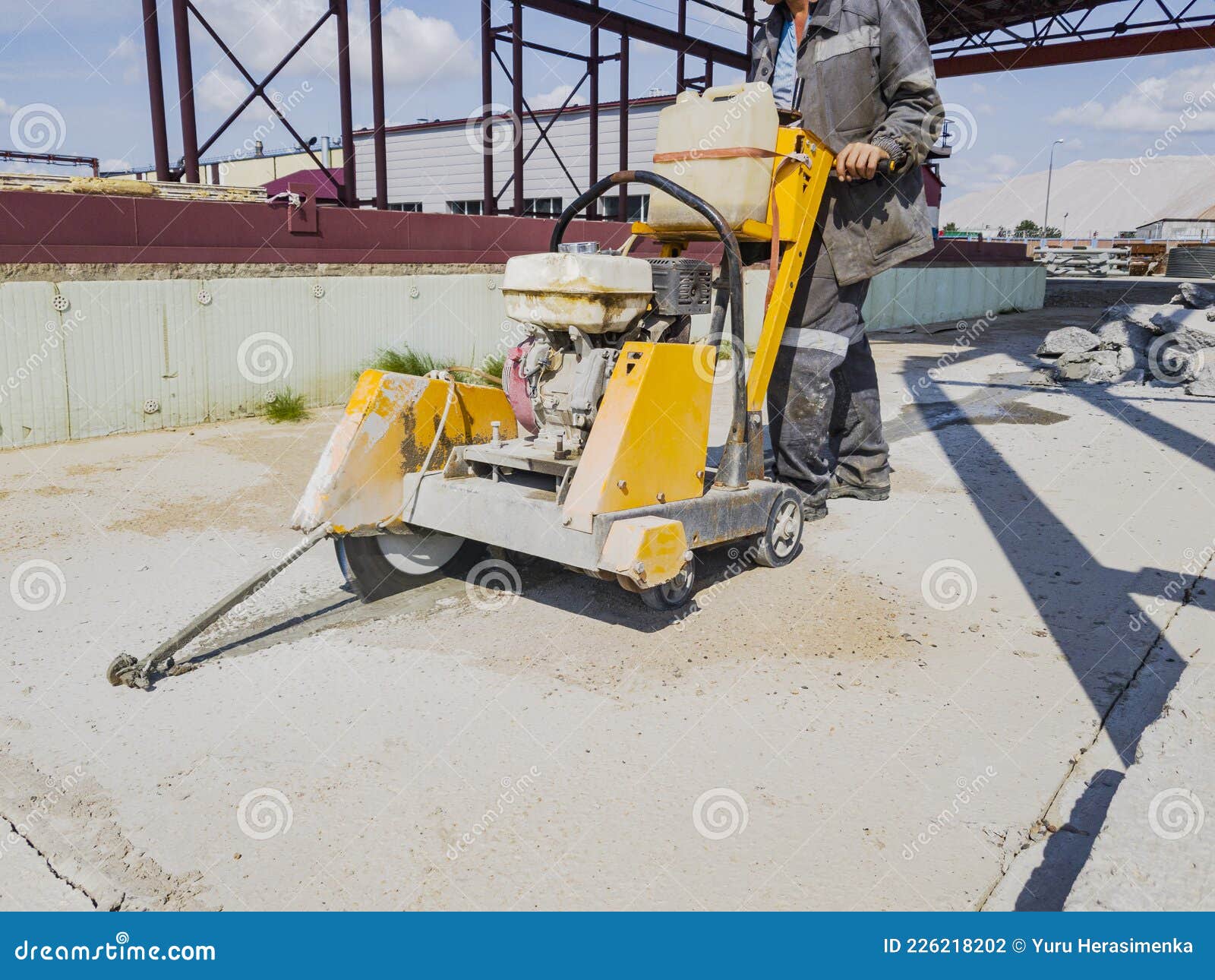 A Worker at a Construction Site Cuts Concrete with a Diamond Saw