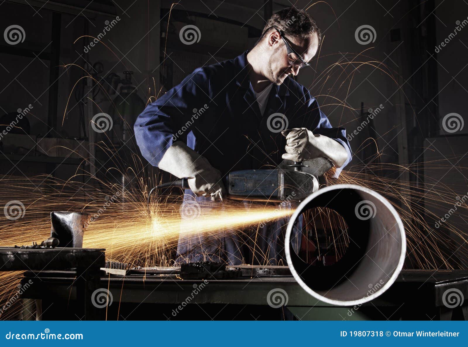 worker cutting pipe with angle grinder.