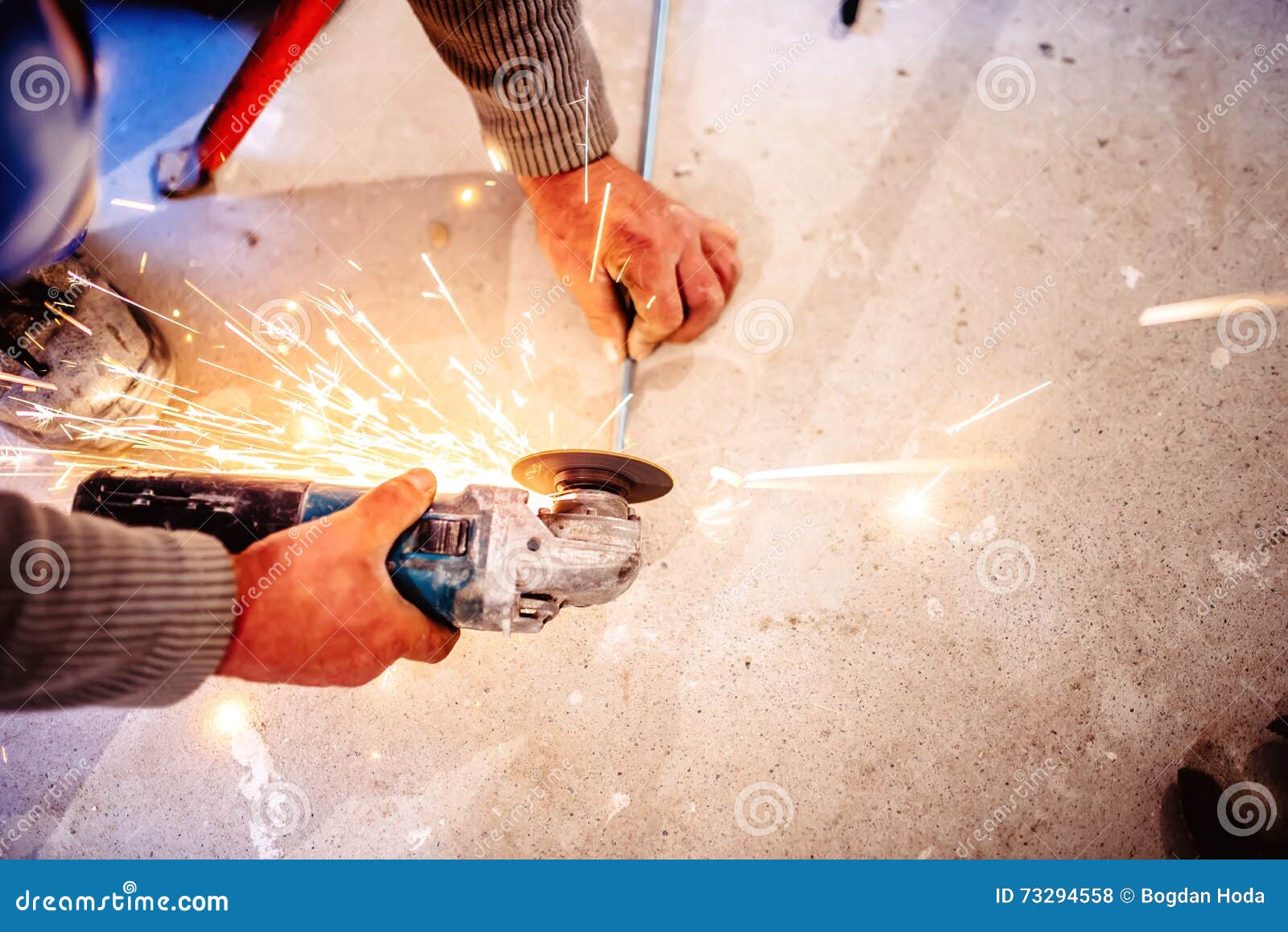 Worker Cutting Steel Bars Using Industrial Manual Grinder Stock Photo