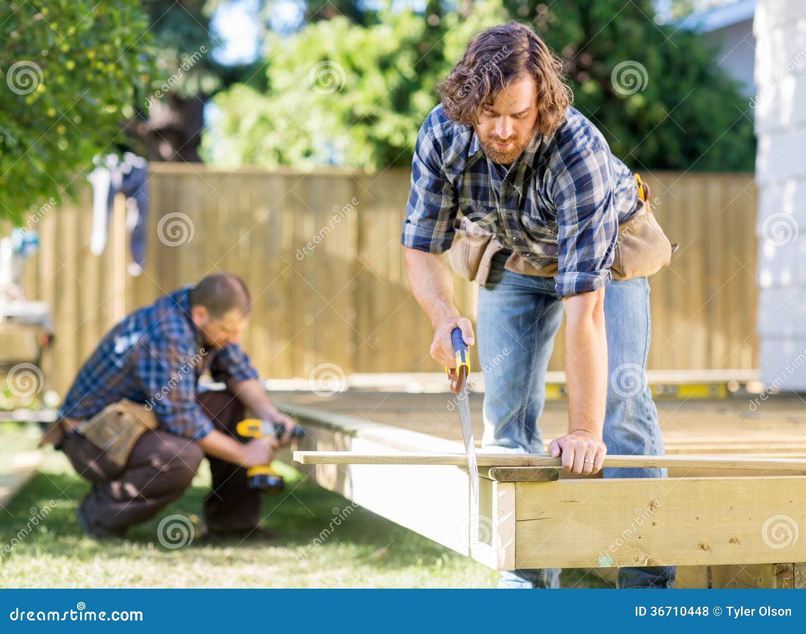 Worker Cutting Wood with Saw while Coworker Stock Photo - Image of ...