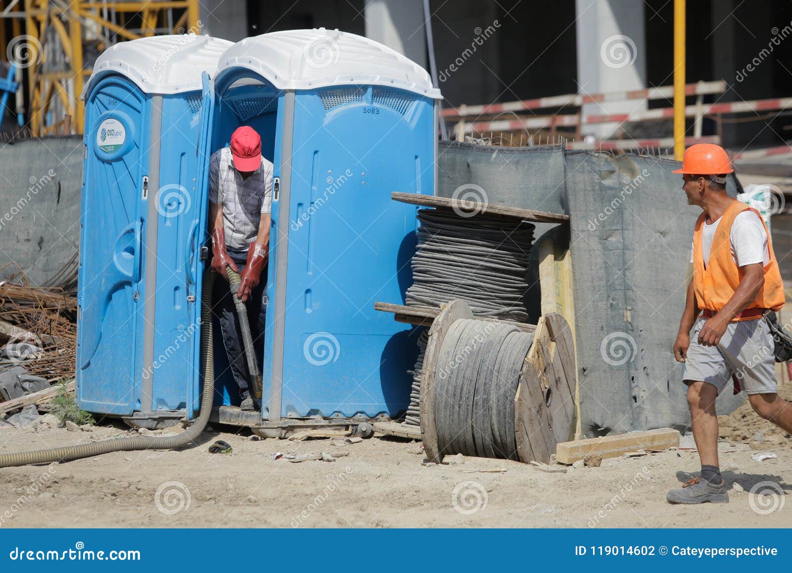 A Worker is Emptying Ecological Toilets on a Construction Site