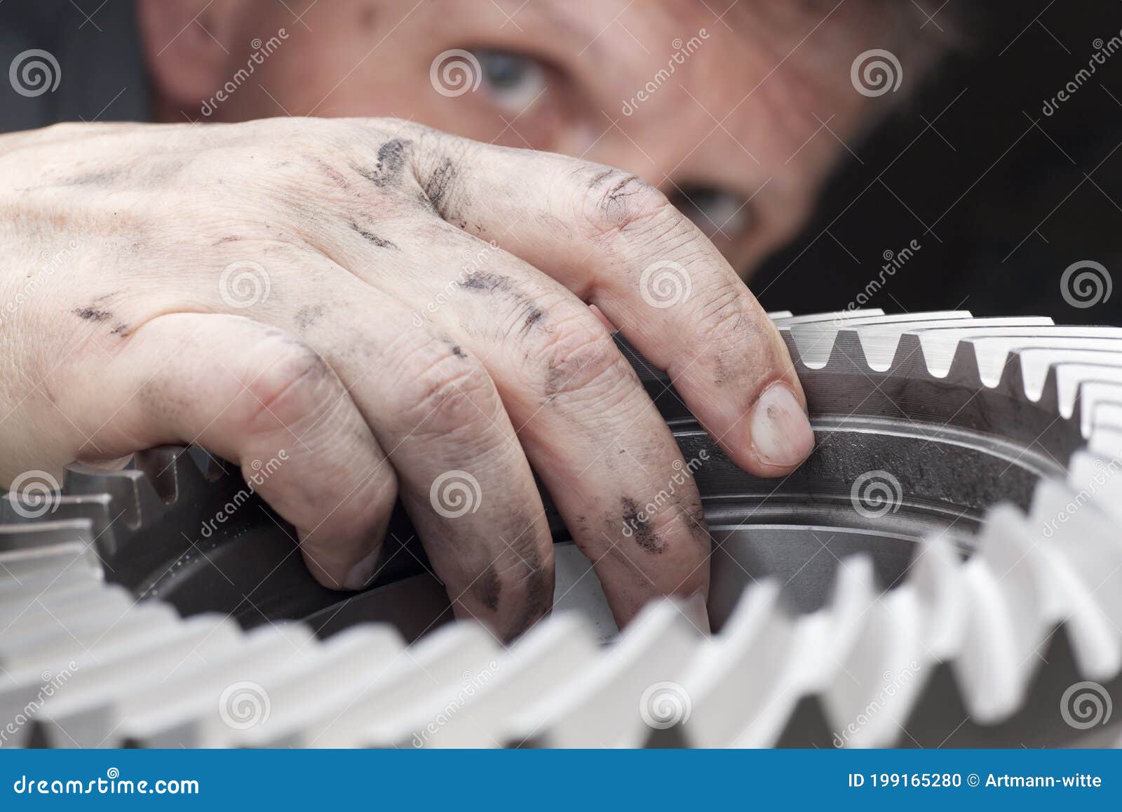 worker examining a spare part - cog wheel