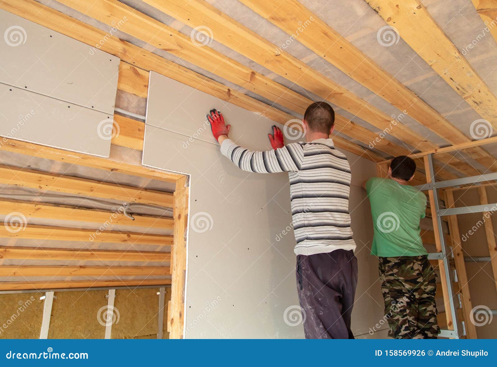A Worker Fastens a Sheet of Drywall To the Wall Editorial Photo Image