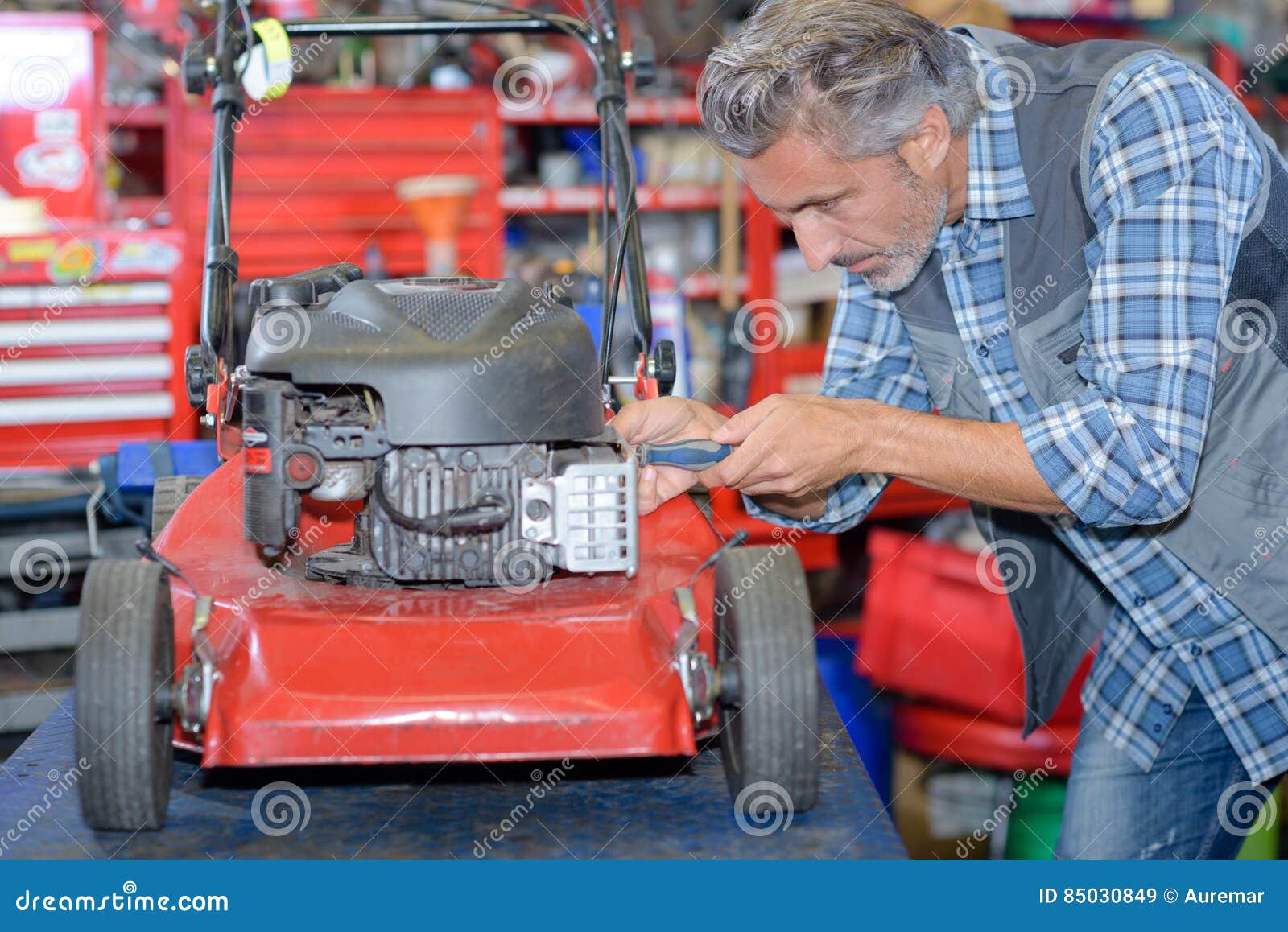 worker fixing lawn mower
