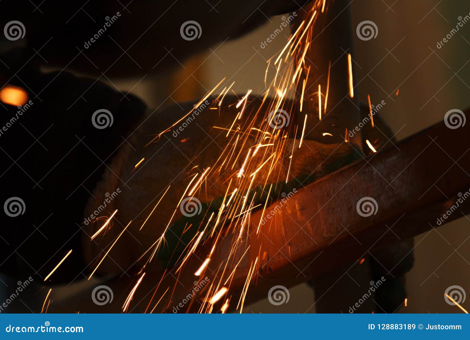 Worker Grinding Cutting Metal Sheet with Grinder Machine and Sparks