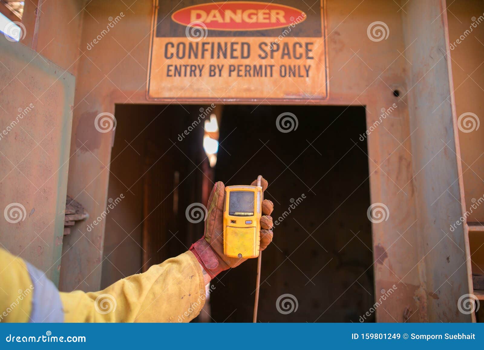 worker hand holding gas test leak detector device at main confined space entry and exit