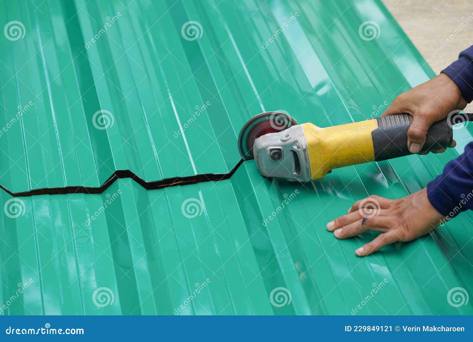 Worker Hands Cutting a Metal Sheet for Roofing by Using an Angle