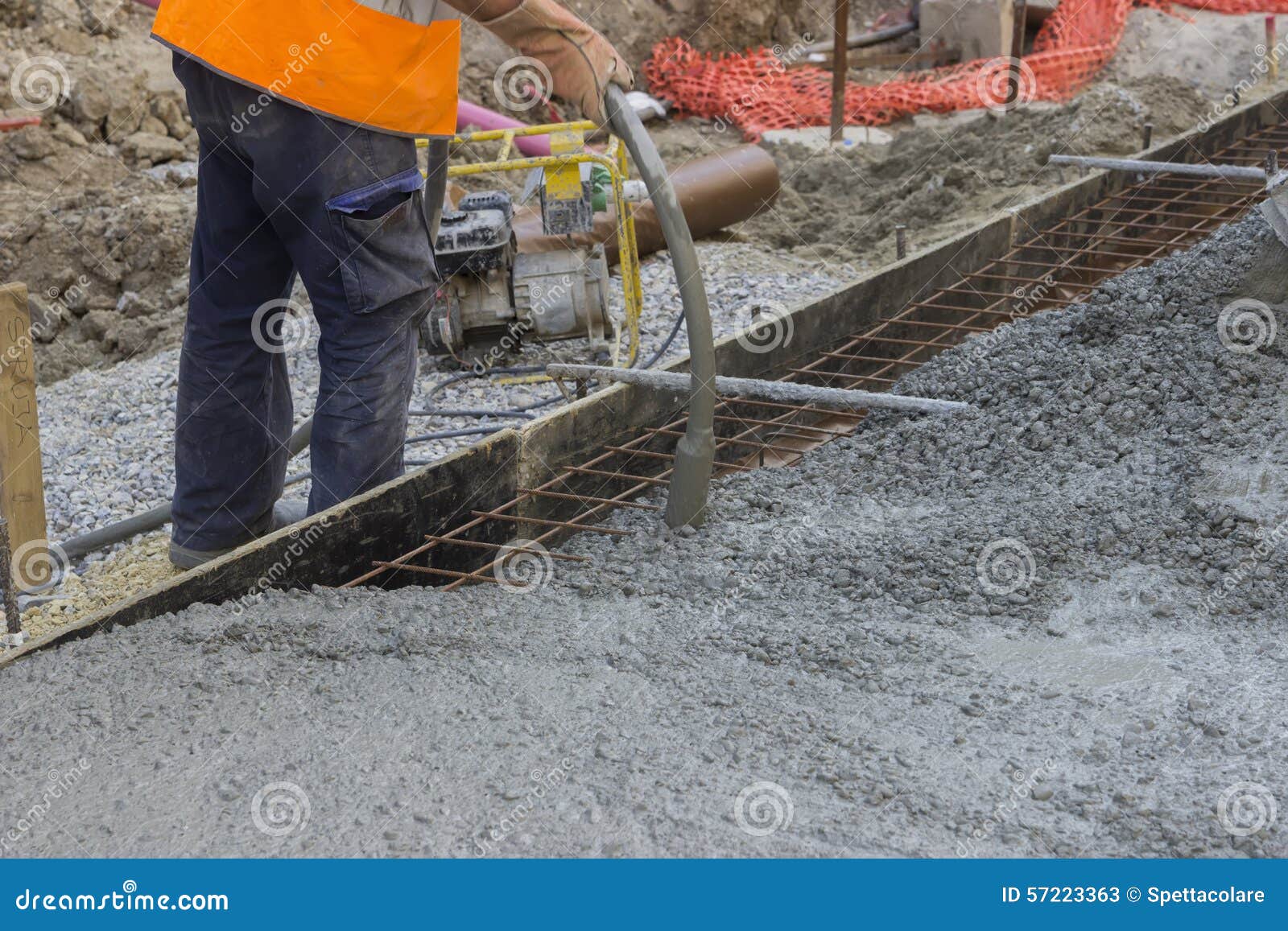 worker hands using concrete vibrator
