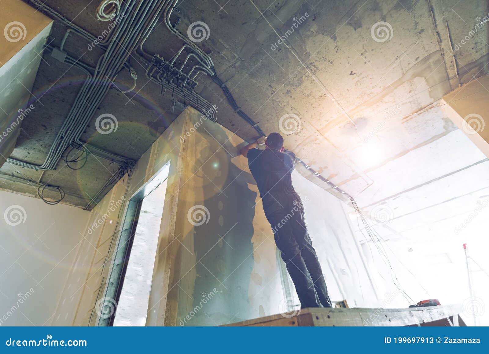 Worker is Installing the Electrical Wires on the Ceiling that is the Part of Internal Wiring in