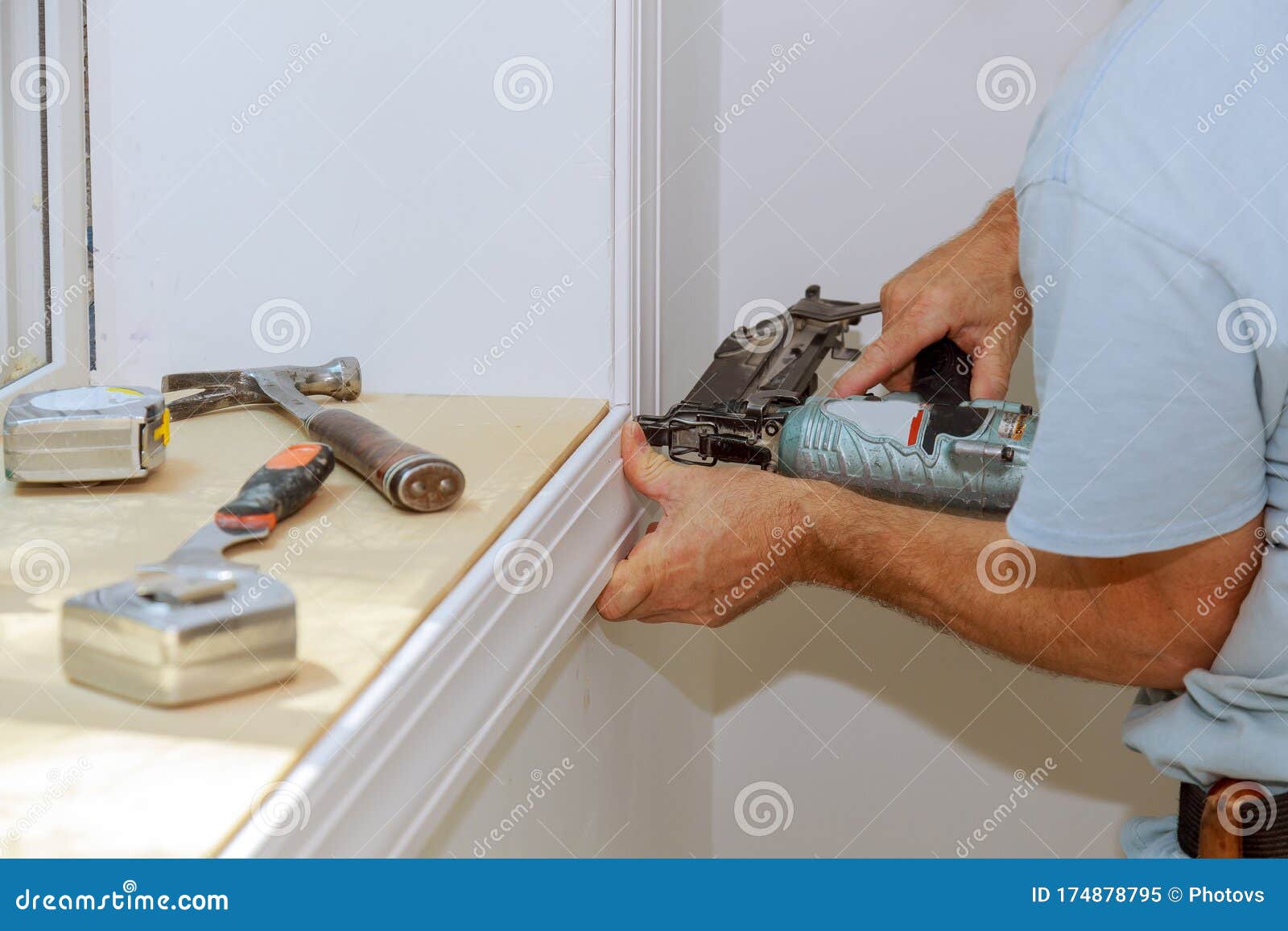 worker installing trim around a window