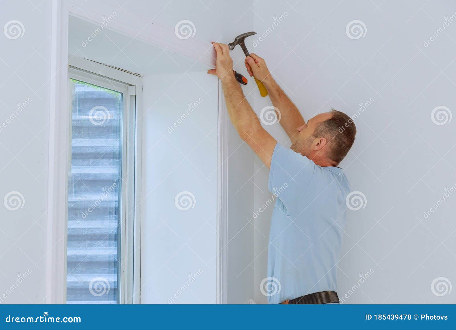 Worker Installing Trim Around a Window Stock Photo Image of brad, lumber 185439478