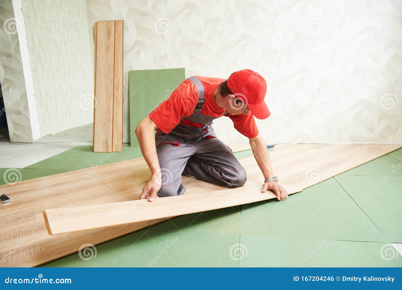 Worker Laying Laminate Floor Covering At Home Renovation Stock