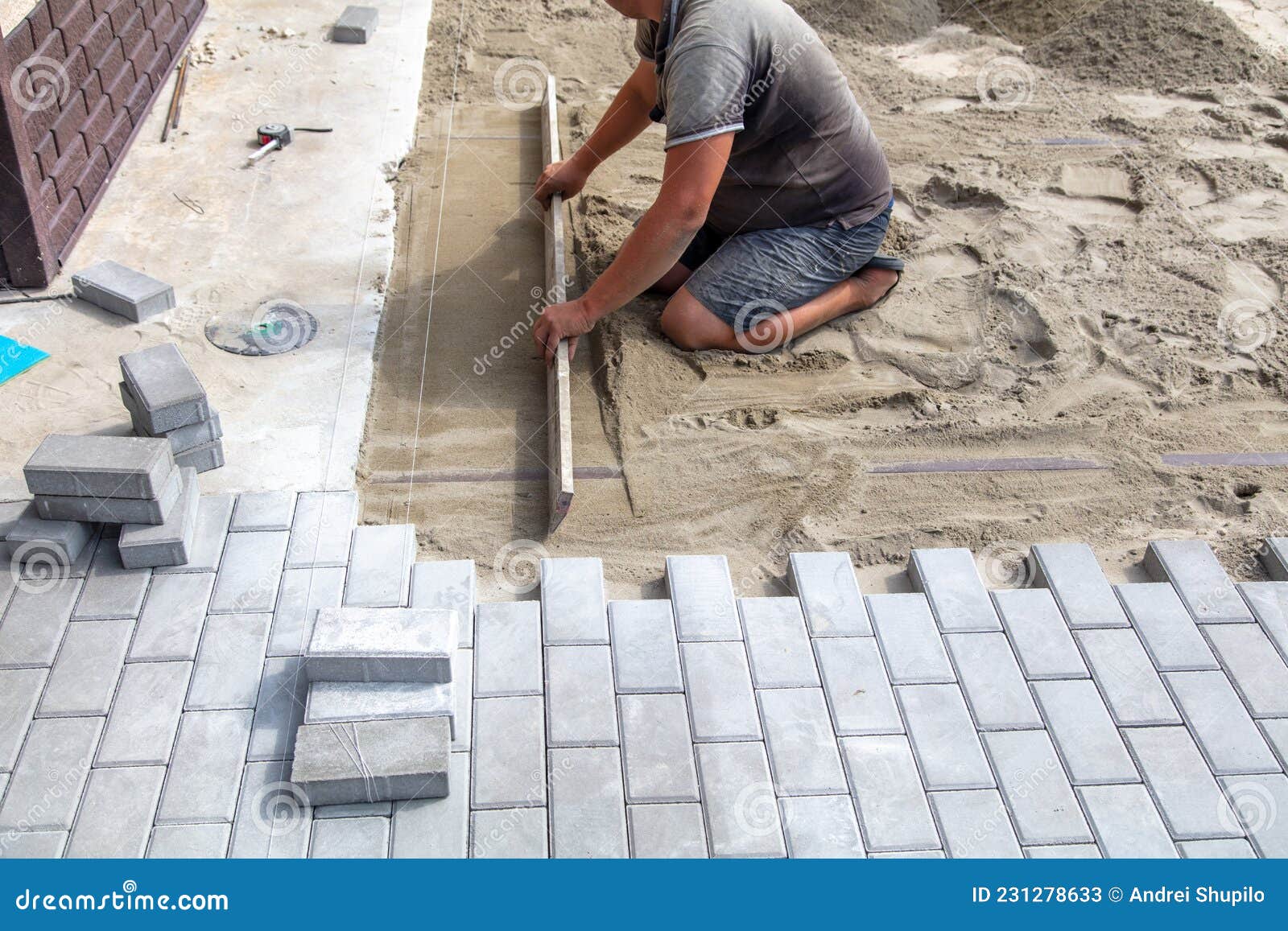 A Worker Lays Down Sand for Paving Slabs. Stock Image Image of work