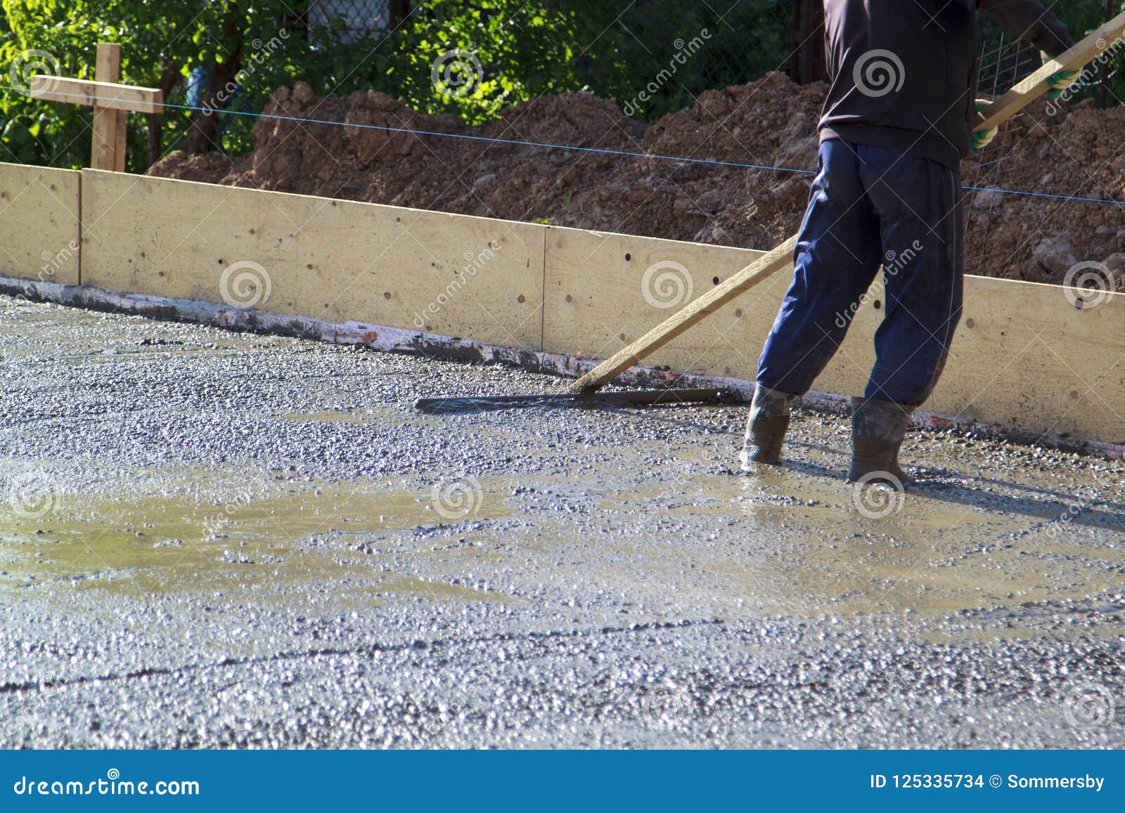 Worker Leveling Fresh Concrete Slab With A Special Working Tool