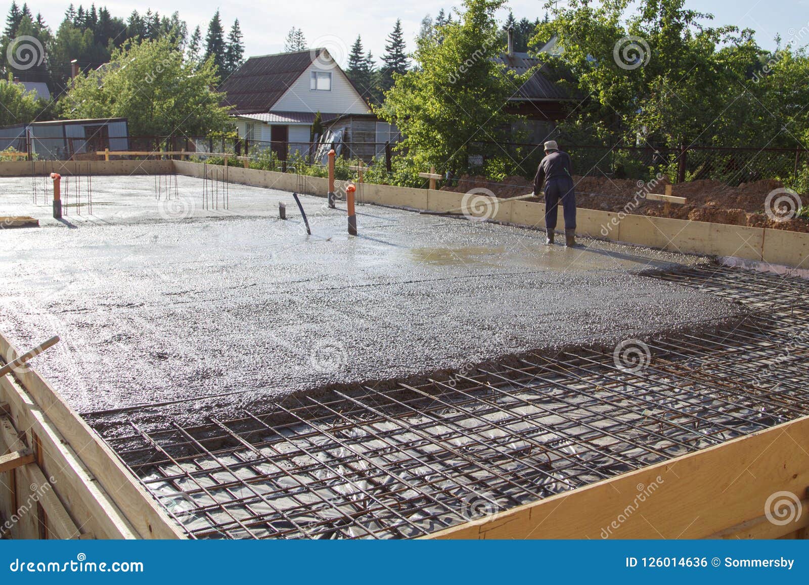 Worker Leveling Fresh Concrete Slab with a Special Working Tool Stock
