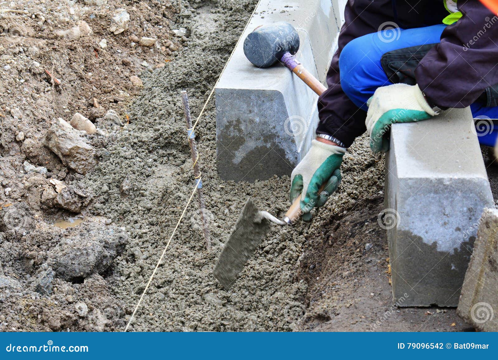Worker Levels and Prepares the Concrete Bedding for the Curbs Using a