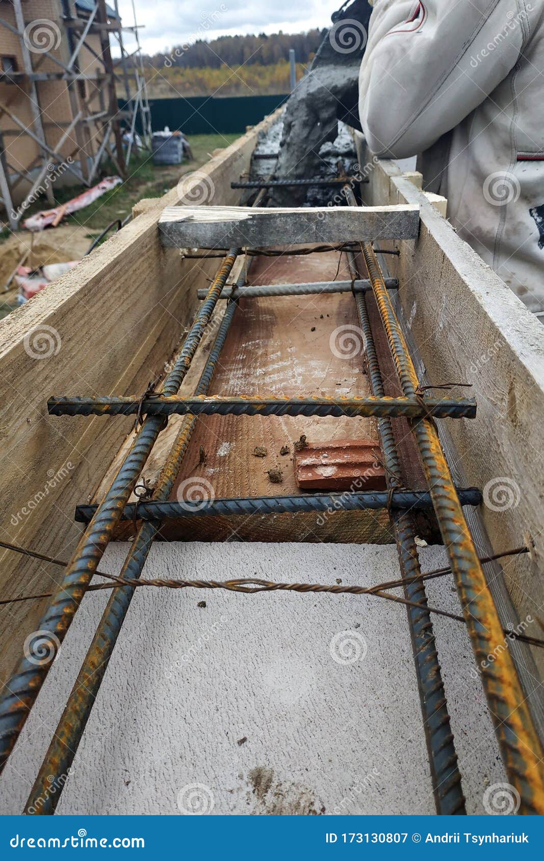 Worker Lines Concrete in Formwork with Trowel, Construction of New Home