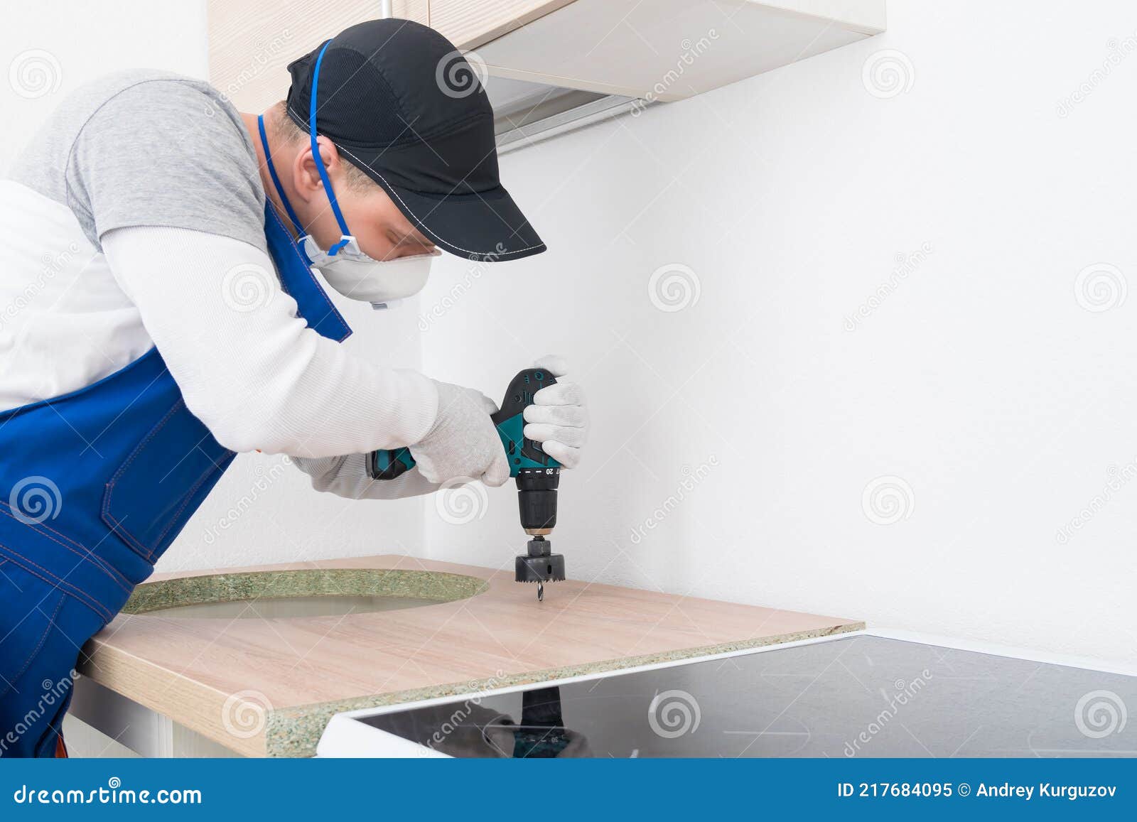A Worker Makes a Hole for Installing a Kitchen Faucet in the Countertop