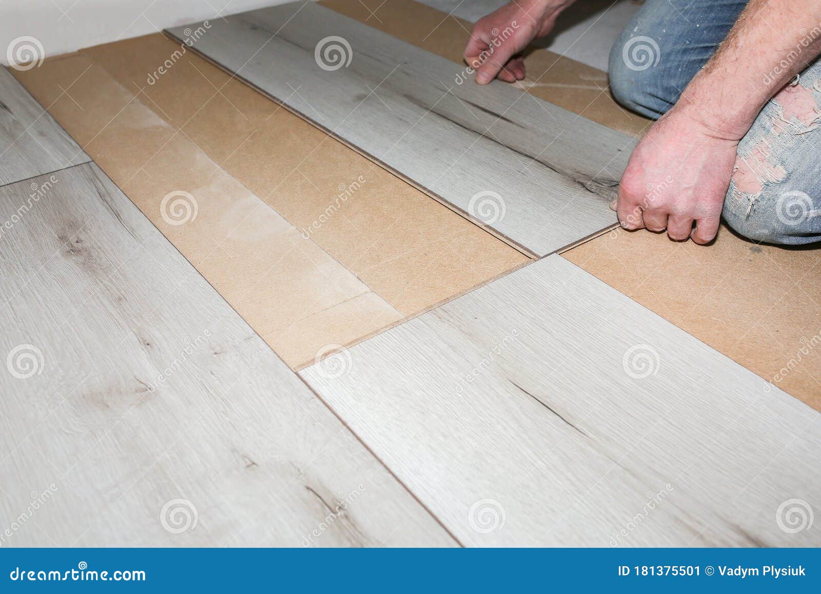 Worker Making Laminate Flooring in Apartment. Maintenance Repair