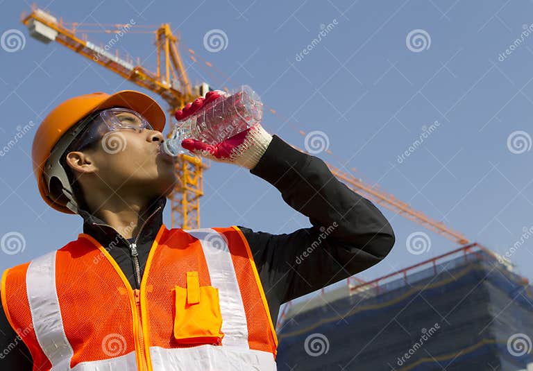 Worker Man As he Drinks from a Plastic Water Bottle Stock Photo Image