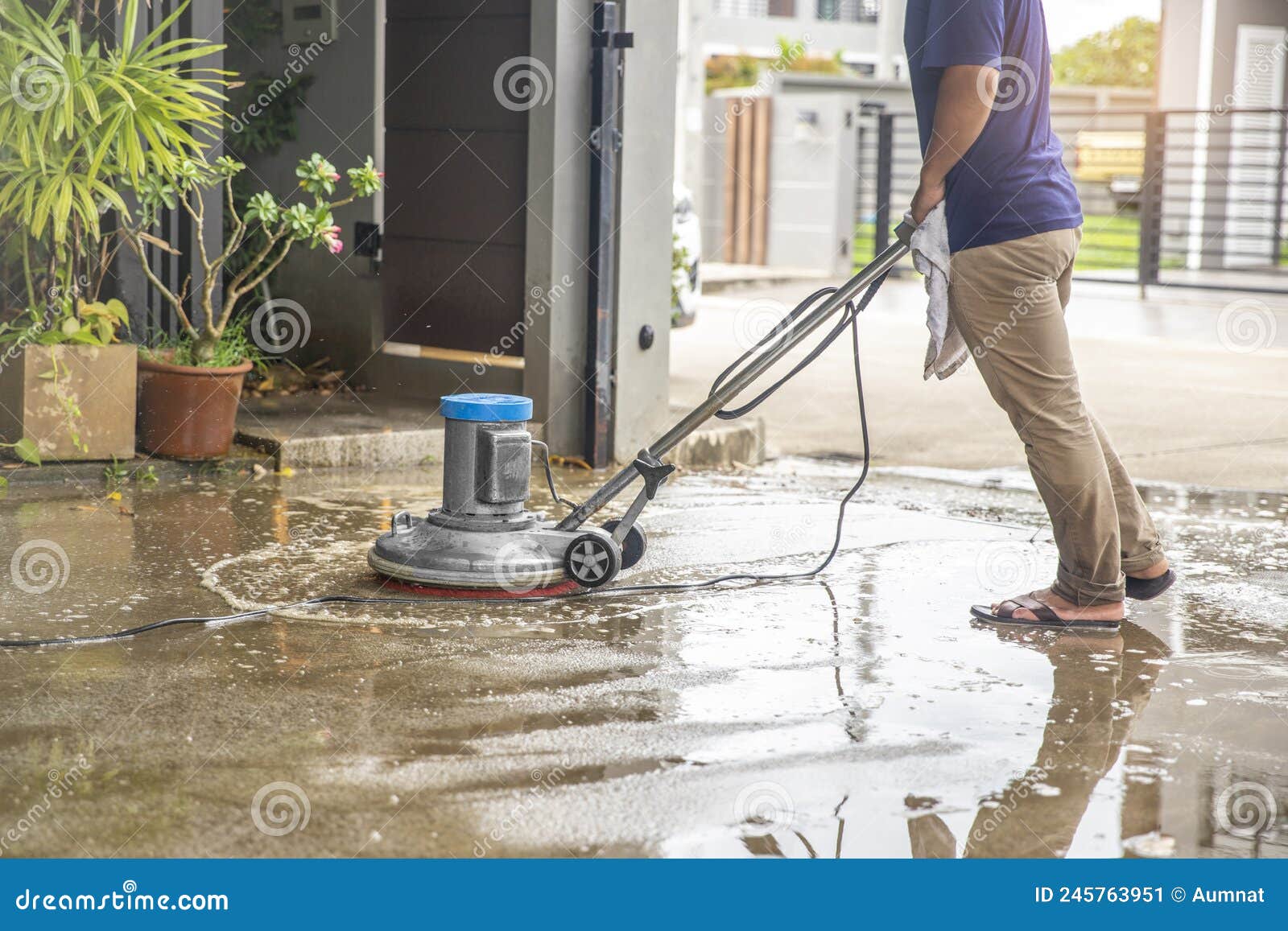 A Worker Man Cleaning and Floor Care by Washing Machine. Outdoors Stock