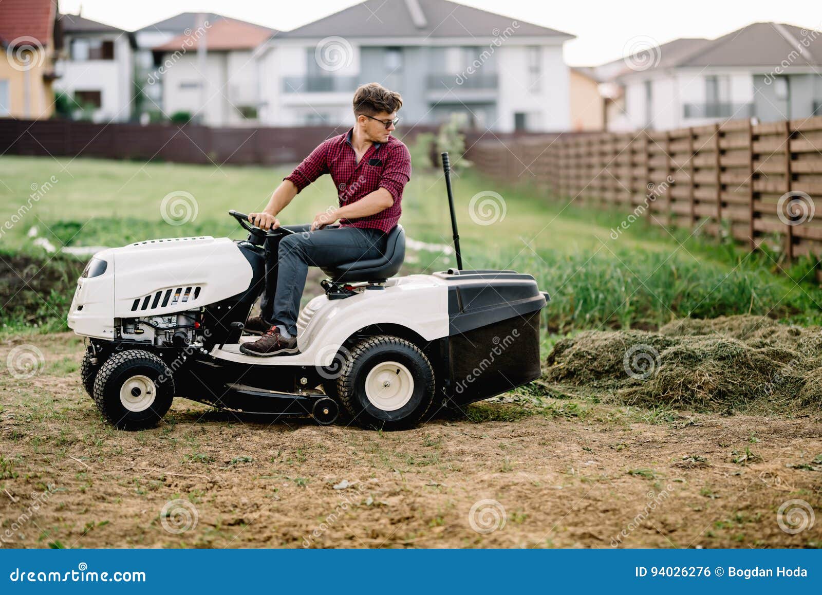Worker Mowing Lawn and Cutting Grass Using Powerful Mower Stock Photo