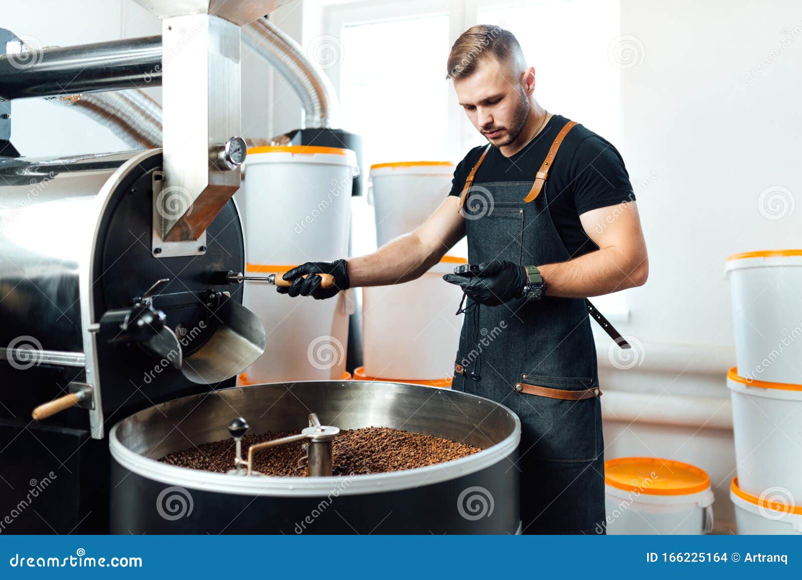 A Worker Near Coffee Roasting Equipment Will Check Time for Testing the