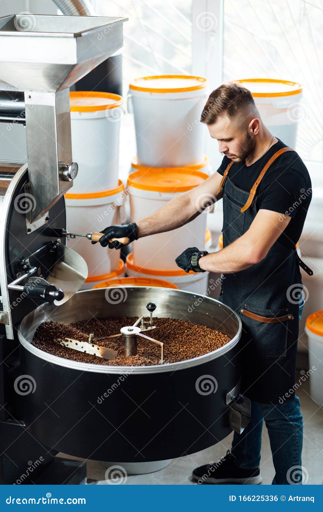 A Worker Near Coffee Roasting Equipment Will Check Time for Testing the